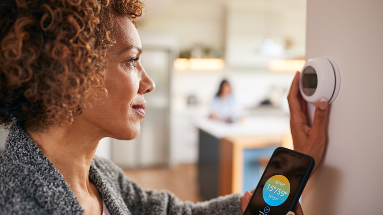 Person adjusting smart thermostat