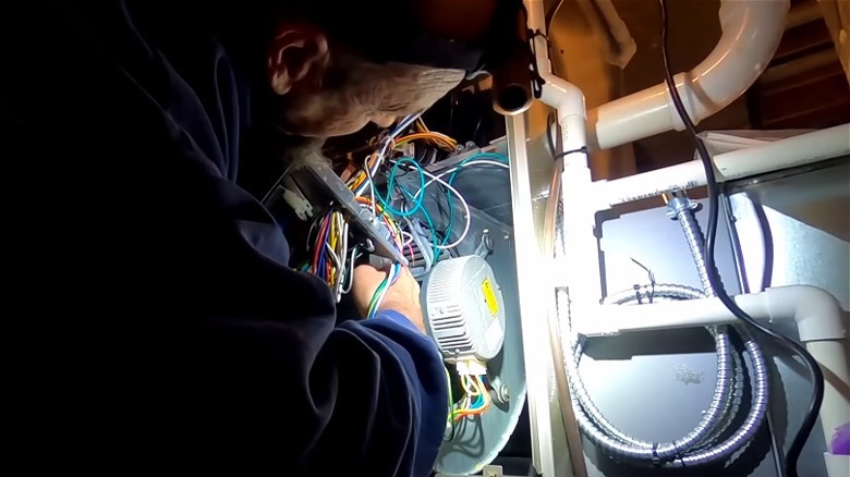 Technician holding part of furnace