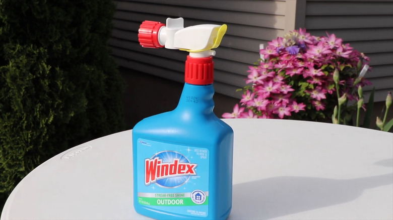 A bottle of Windex Outdoor window and glass cleaner sprayer on table