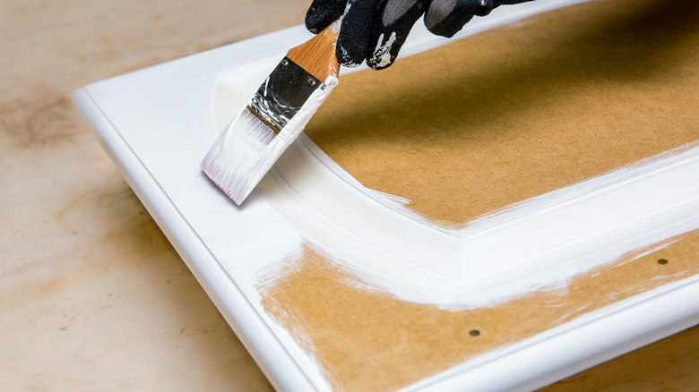 person painting cabinet with chalk paint