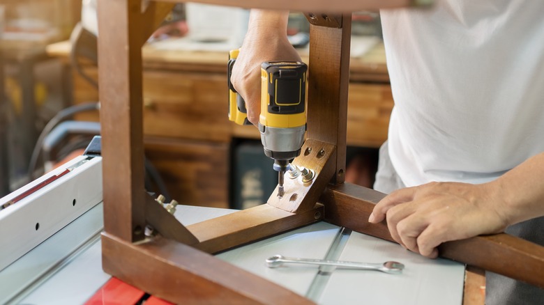 Person using a screwdriver on a chair