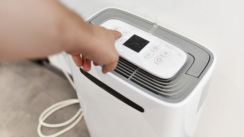 Hand turning on dehumidifier