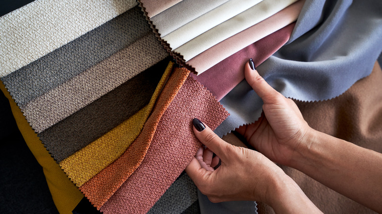 person examining fabric swatches 