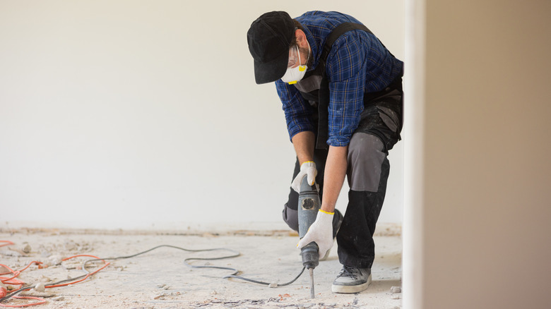 worker removing floor wearing safety mask