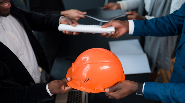 men exchanging permits and ppe