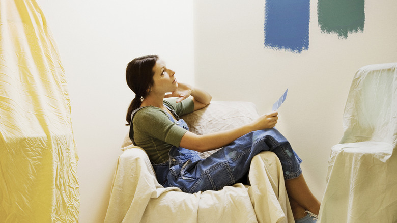 Woman comparing paints on wall