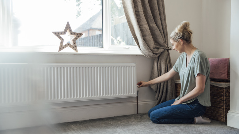 Woman adjusting radiator