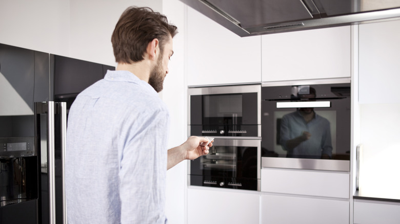 Man standing in front of built-in kitchen appliances