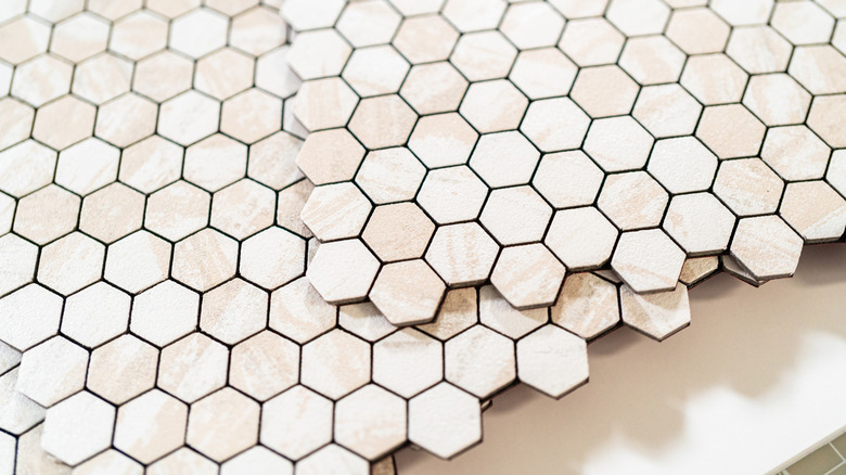 Sheets of light brown peel-and-stick tile on a table