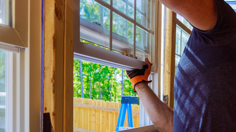 A person installing or repairing a window