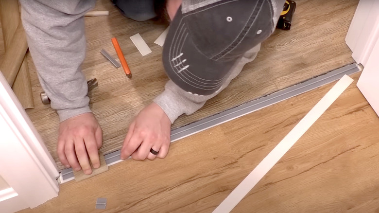 young man installing doorway transition strip