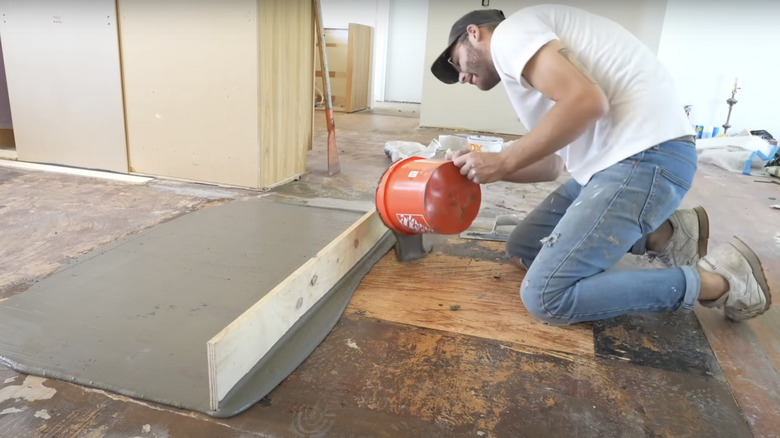 young man prepping subfloor for vinyl planks