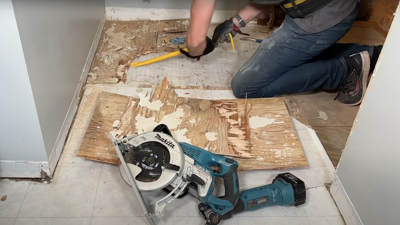 man removing old vinyl and linoleum flooring