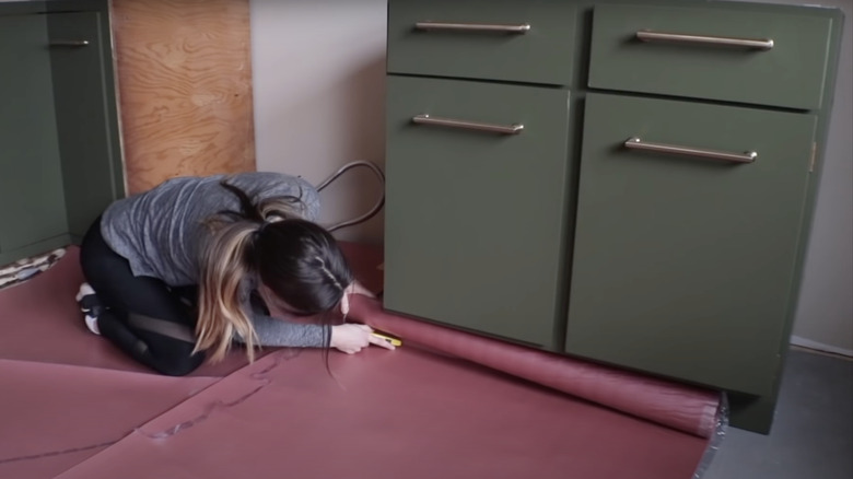 young woman laying vinyl moisture barrier