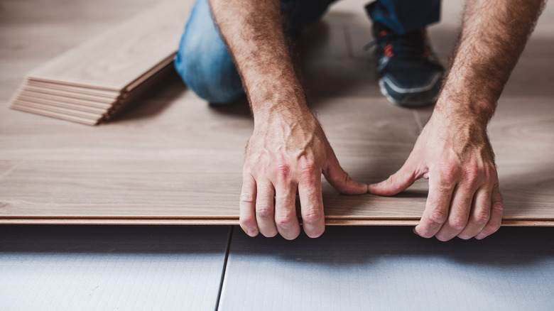 man installing click-and-lock vinyl plank