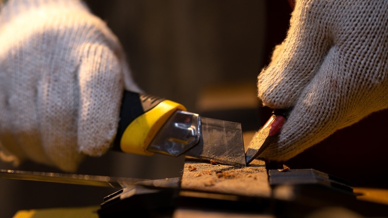 person sharpening a carpenter's pencil