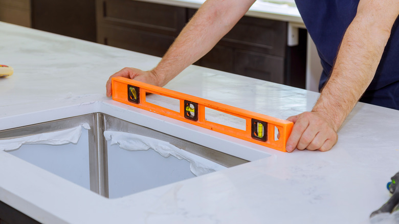 person using level on countertop
