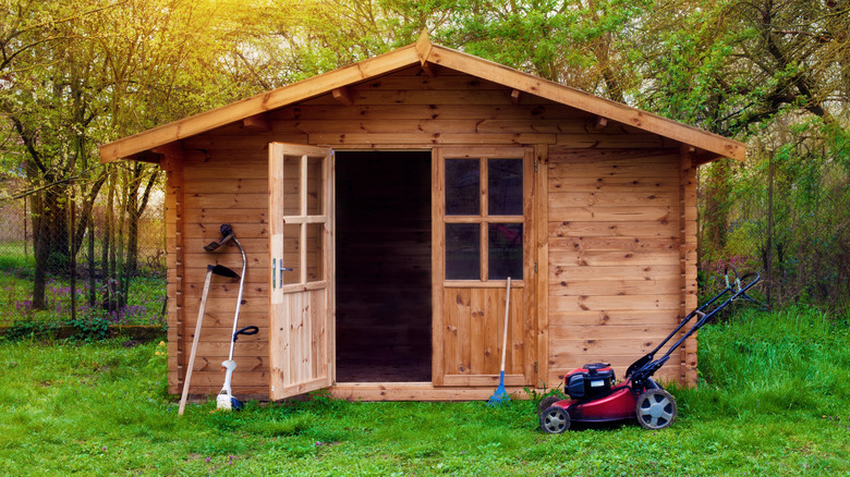 Wood shed with garden tools