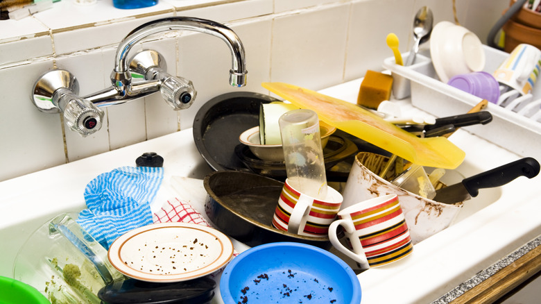 dirty white sink filled with food-covered dishes