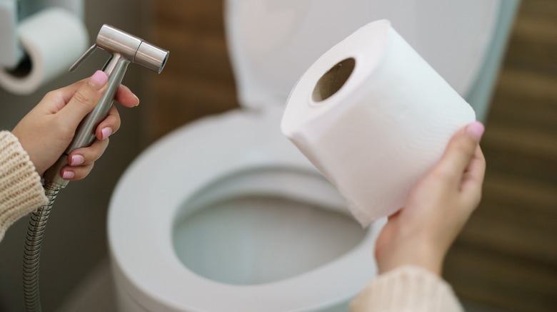 woman comparing bidet to toilet paper