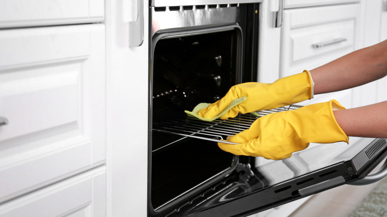 person cleaning oven grate