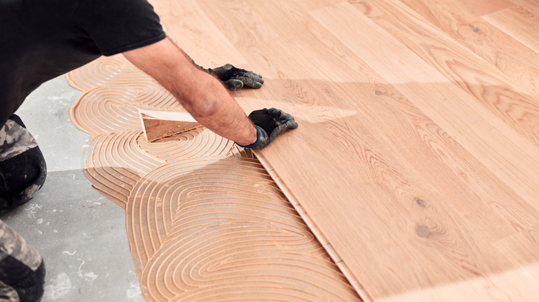 A man gluing down bamboo flooring