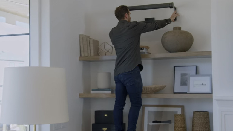 Man installing a living room shelf