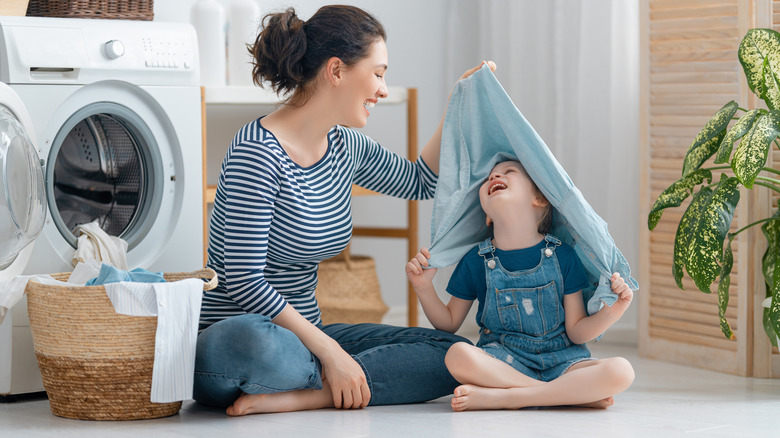 Woman and child playing with laundry