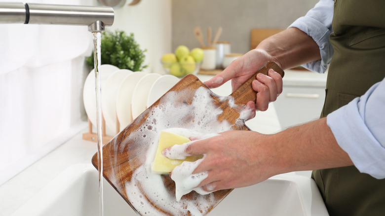 Man washing a wood cutting board