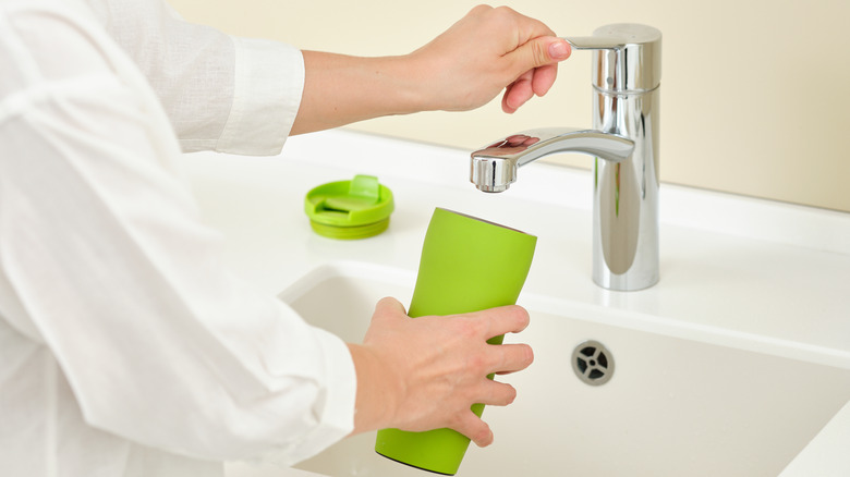 person washing thermos