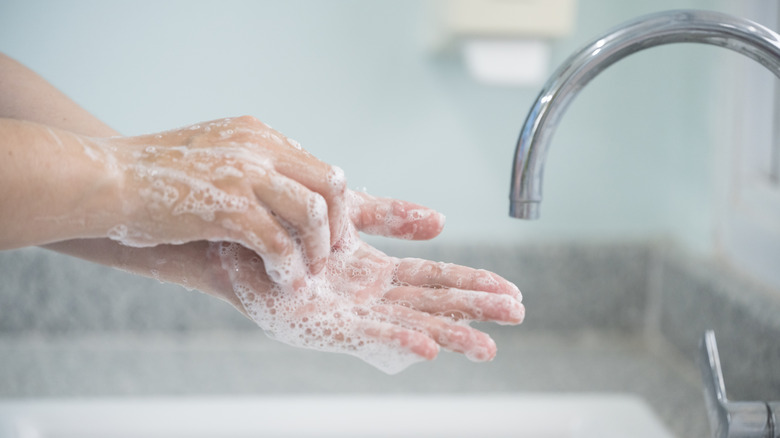 Person scrubbing their hands clean at sink