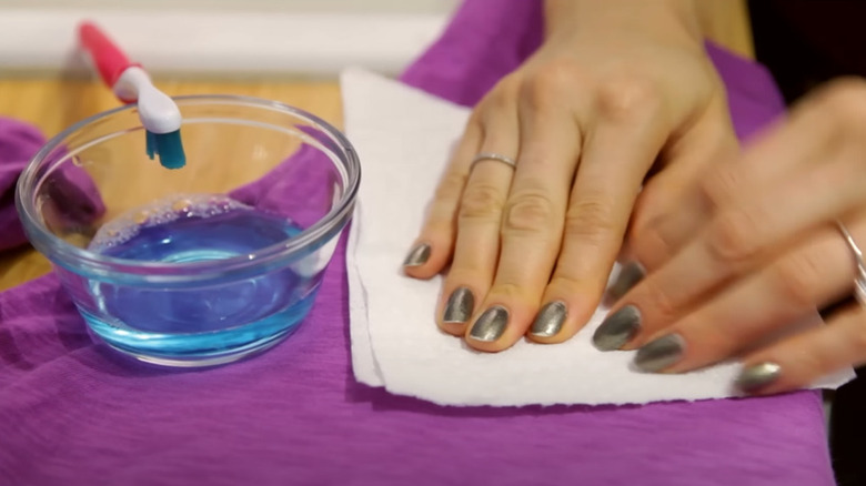 Hands blotting a stain with paper towel