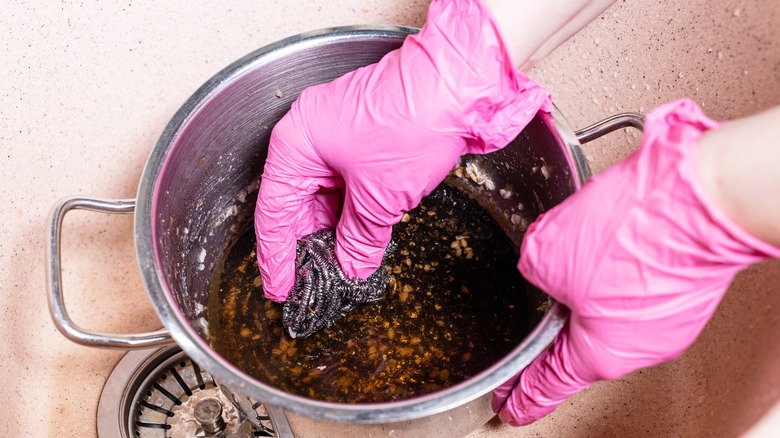 person scrubbing pot