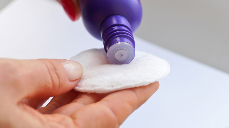 Applying nail polish remover to cotton