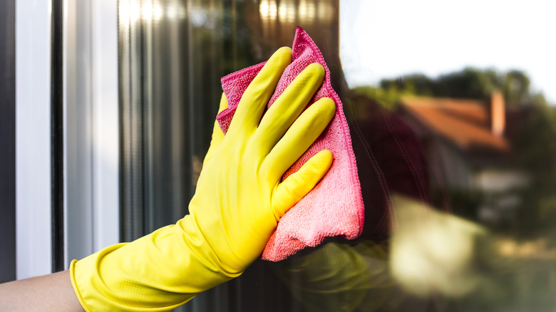 Gloved hand cleans window