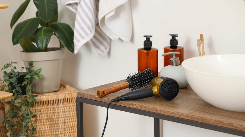 Hair tools on wood countertop near soap jars