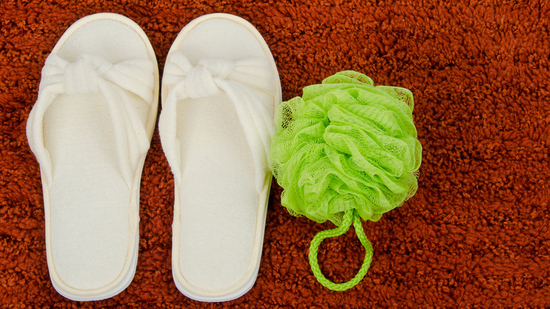 slippers and loofah on high-pile bath mat