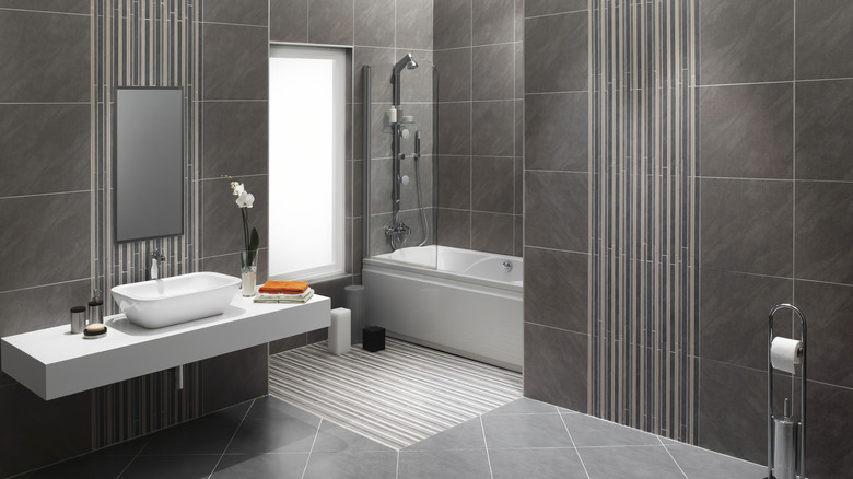 A bathroom with large grey tiles to make a statement