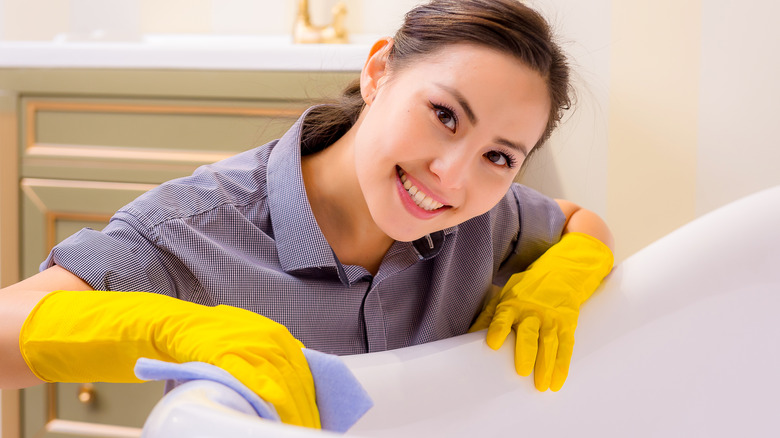 woman wipes bathtub clean