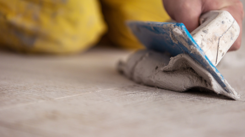 person spreading grout