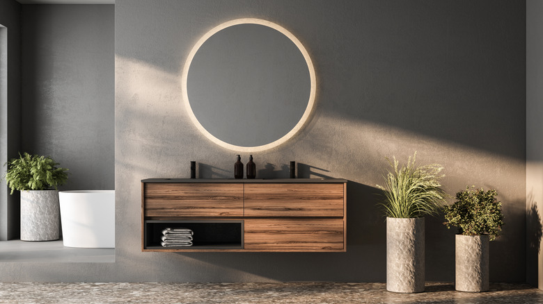 Dark grey bathroom with wood cabinet and green and white accents