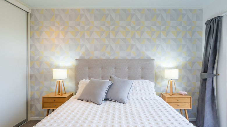 bed with floral painting behind headboard in arch-shaped frame