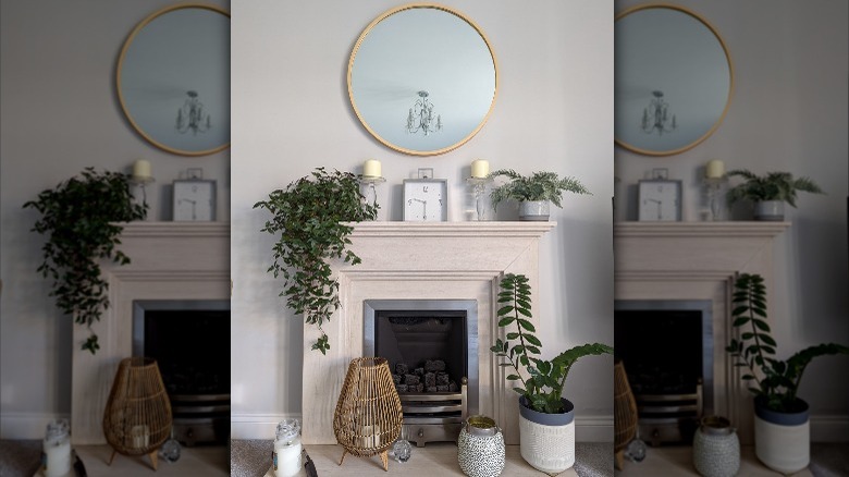 Round mirror above fake fireplace