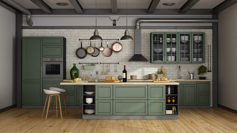 Green kitchen island against white brick