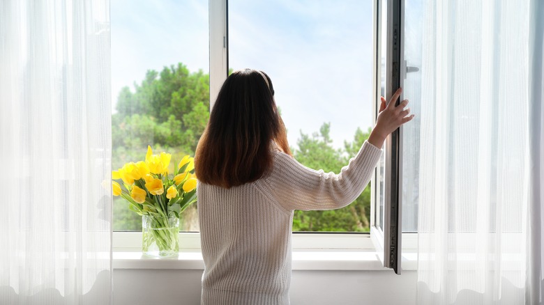 woman looking out open window