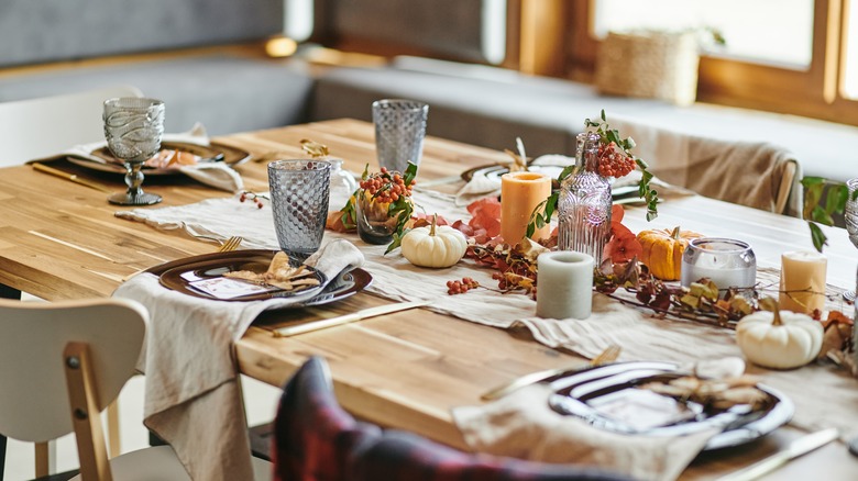 Tableware and candles on wooden table 