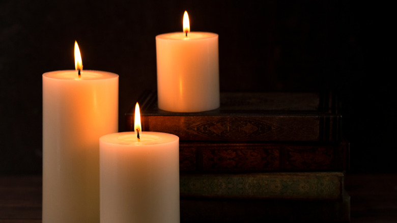 Three candles lit black background