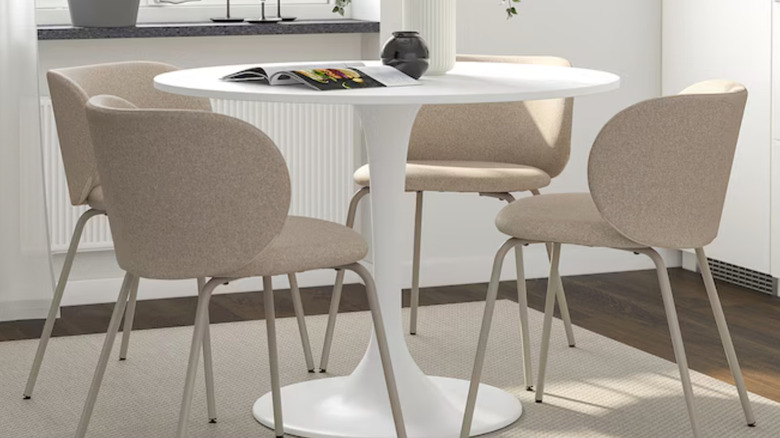 The white DOCKSTA table is surrounded by taupe chairs