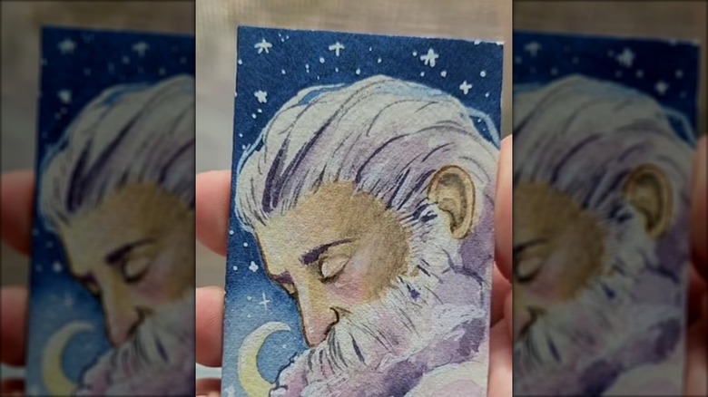 Person holding a beautifully painted business card they turned into art