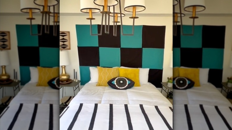 A bed headboard made from green and white square cloth napkins hung on the wall.